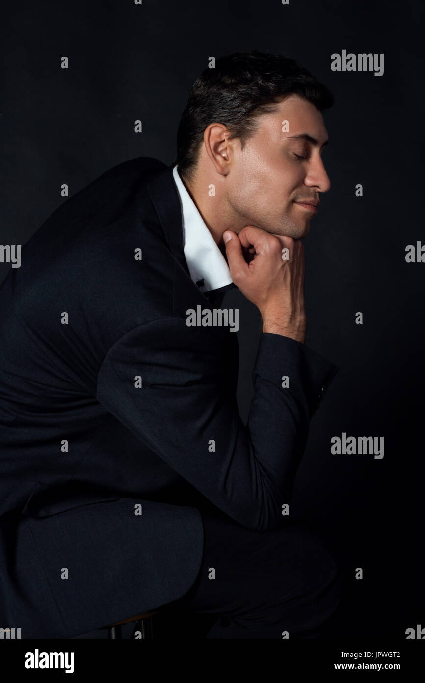 Handsome young man in suit on the black background Stock Photo - Alamy