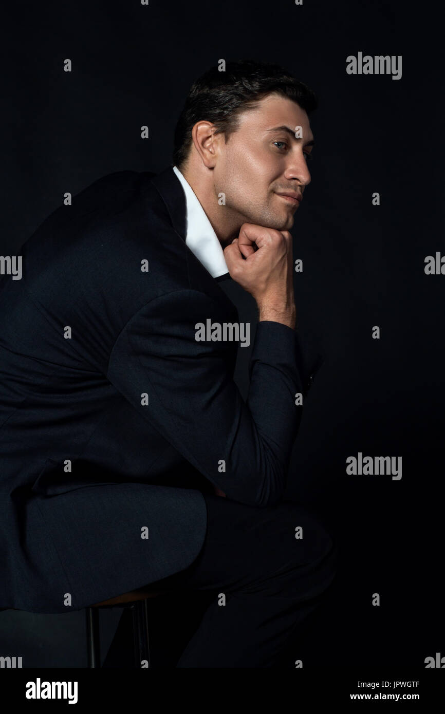 Handsome young man in suit on the black background Stock Photo - Alamy