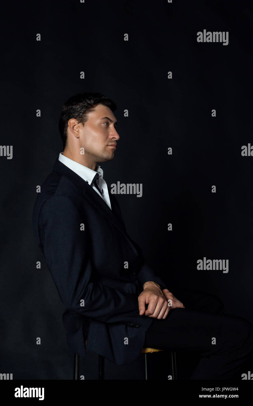 Handsome young man in suit on the black background Stock Photo - Alamy