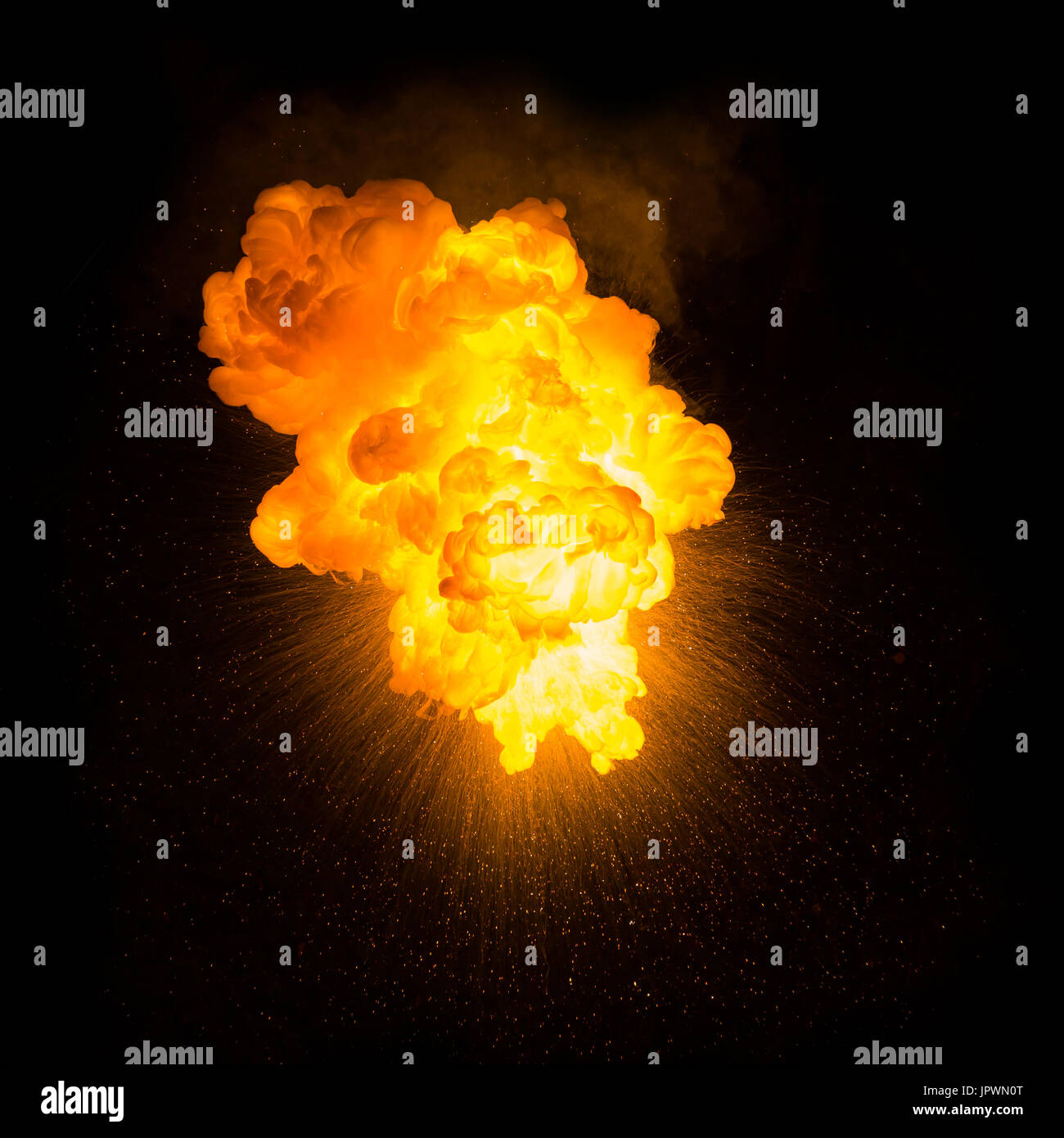 Realistic fiery explosion with sparks over a black background Stock Photo