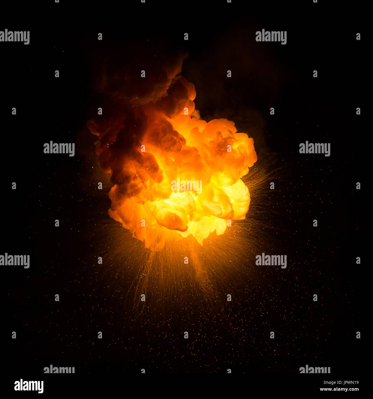 Realistic fiery explosion with sparks over a black background Stock Photo