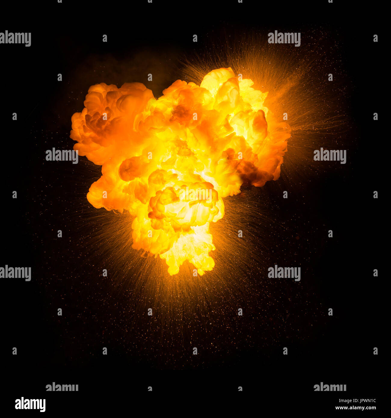 Realistic fiery explosion with sparks over a black background Stock Photo