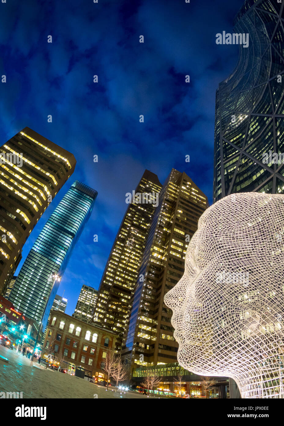 A night, fisheye view of the sculpture Wonderland by Jaume Plensa, in front of The Bow skyscraper in Calgary, Alberta, Canada. Stock Photo