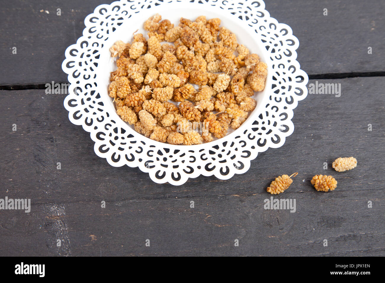 Dried mulberries on wooden background Stock Photo