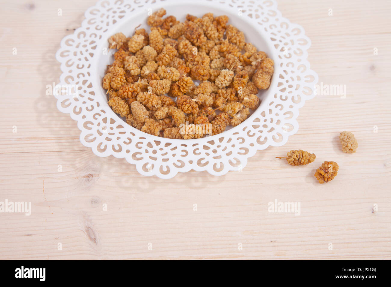 Dried mulberries on wooden background Stock Photo