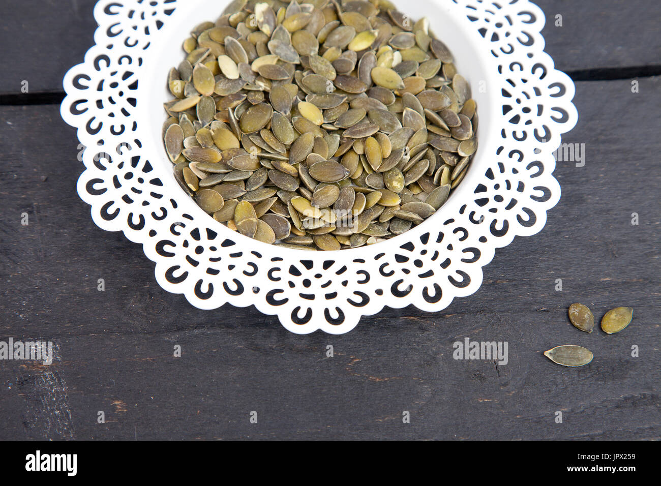 Pumpkin seed in white bowl on wooden background Stock Photo