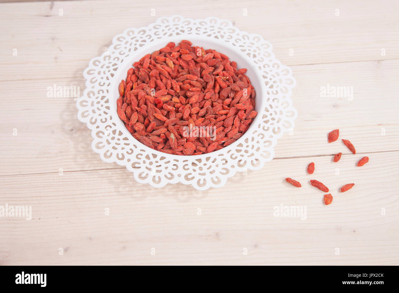 Dried goji berries in white bowl on wooden background Stock Photo