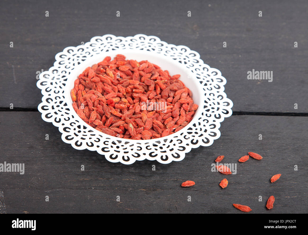 Dried goji berries in white bowl on wooden background Stock Photo