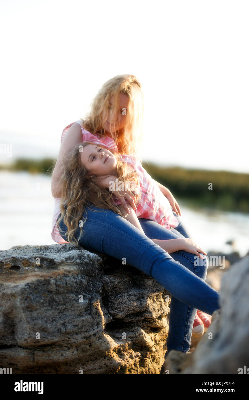 Happy Beautiful Mother And Her Daughter Having Fun On The Rocky Beach 