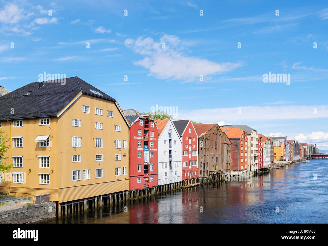 Colourful historic wooden warehouse buildings on stilts on River Nidelva waterfront in old town in summer. Trondheim Norway Scandinavia Stock Photo