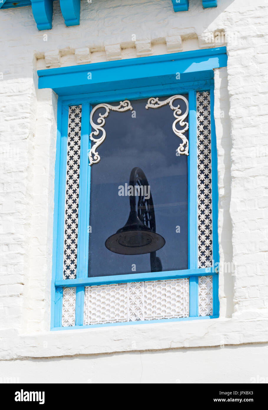 Ornate Ammonite design streetlamp, design reflects the towns location on the Jurassic Coast, reflected in building window at Lyme Regis, Dorset Stock Photo