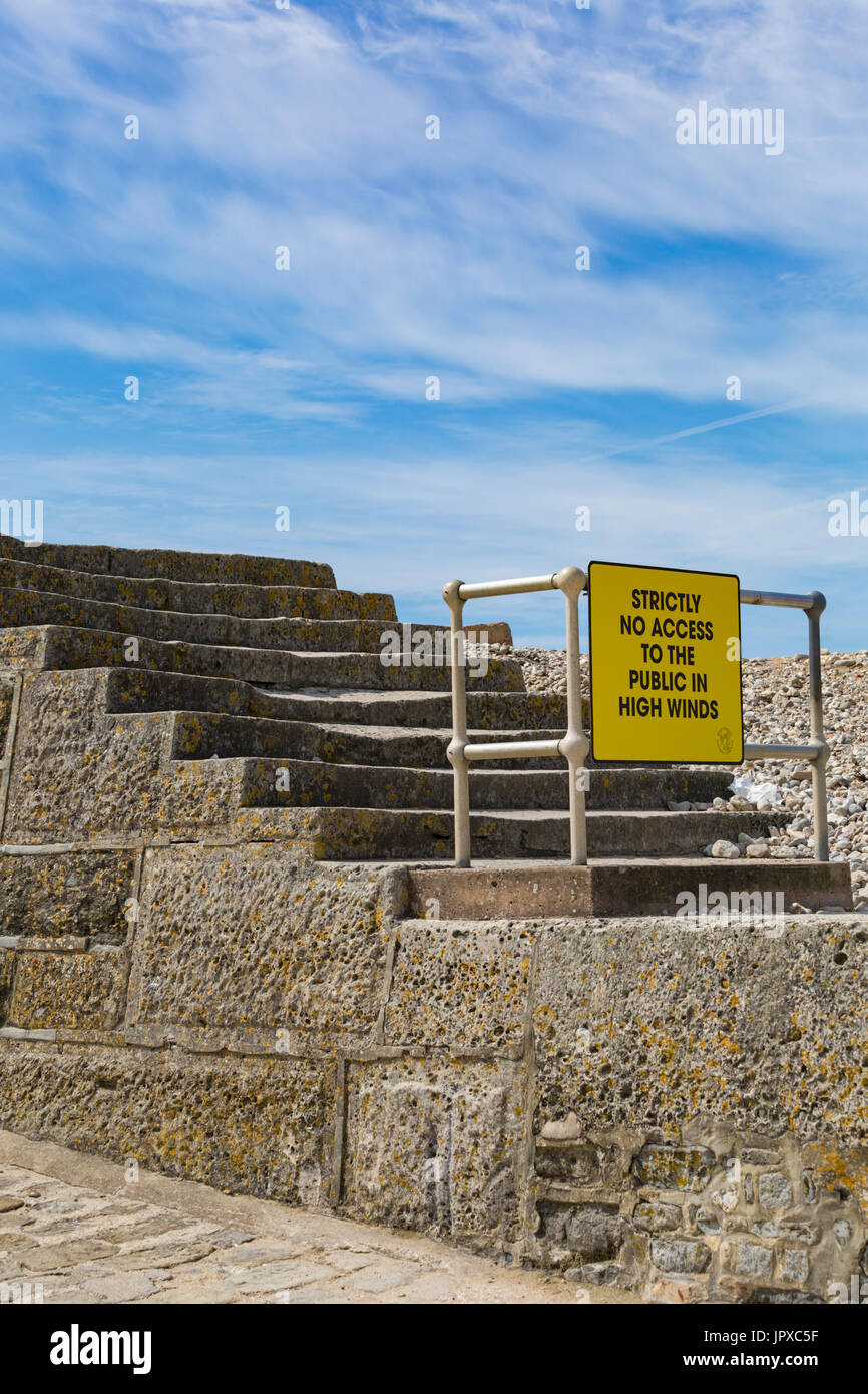 Strictly no access to the public in high winds sign on steps leading to the Cobb at Lyme Regis, Dorset in July Stock Photo