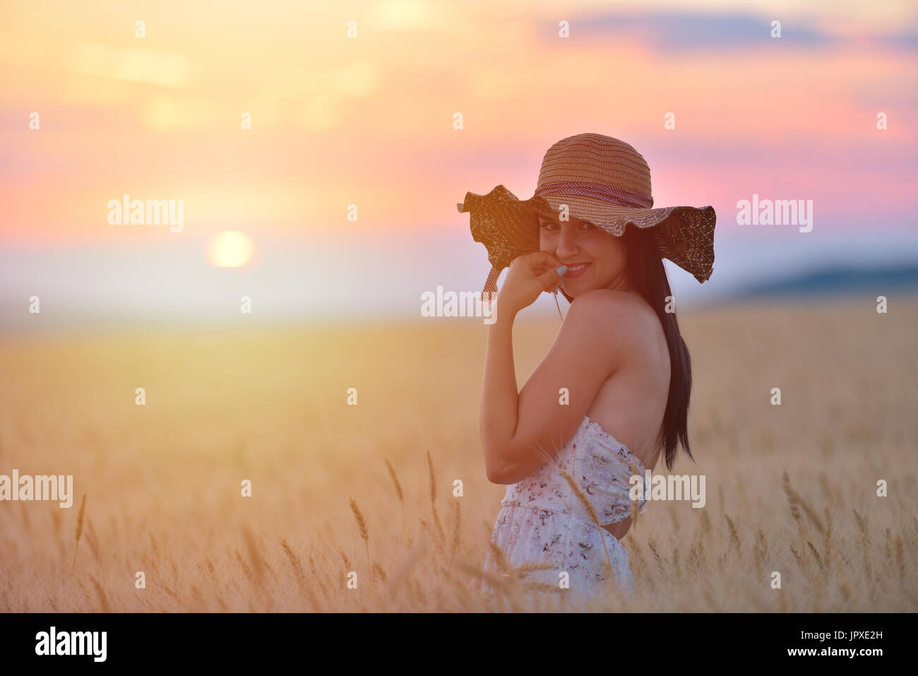 Closeup portrait of smiling young caucasian woman in nature. Cheerful young beautiful woman enjoying a day in natural enviroment at sunset. Stock Photo
