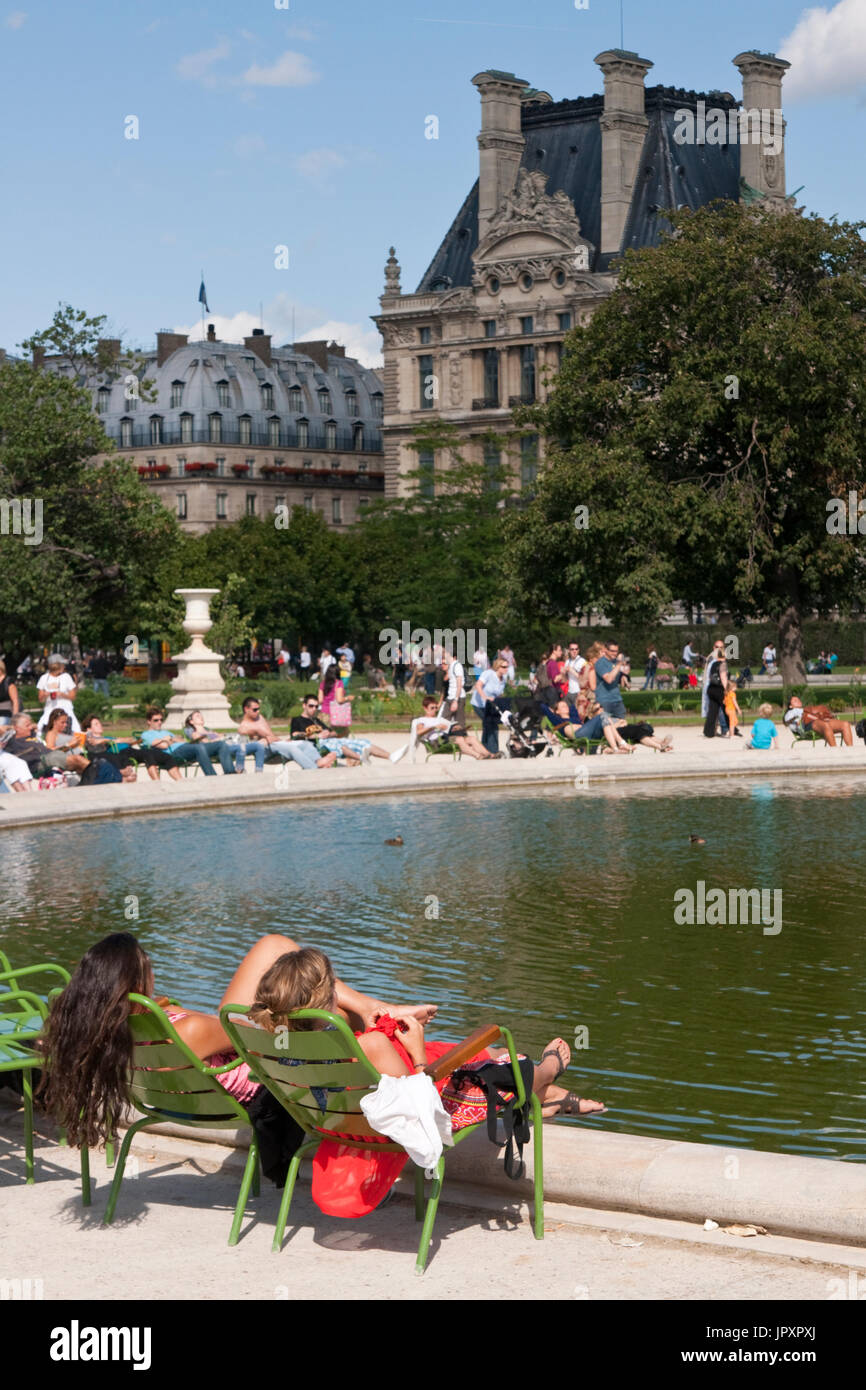 French women relaxing by an ornamental lake in the Jardin des Tuileries in Paris, France Stock Photo