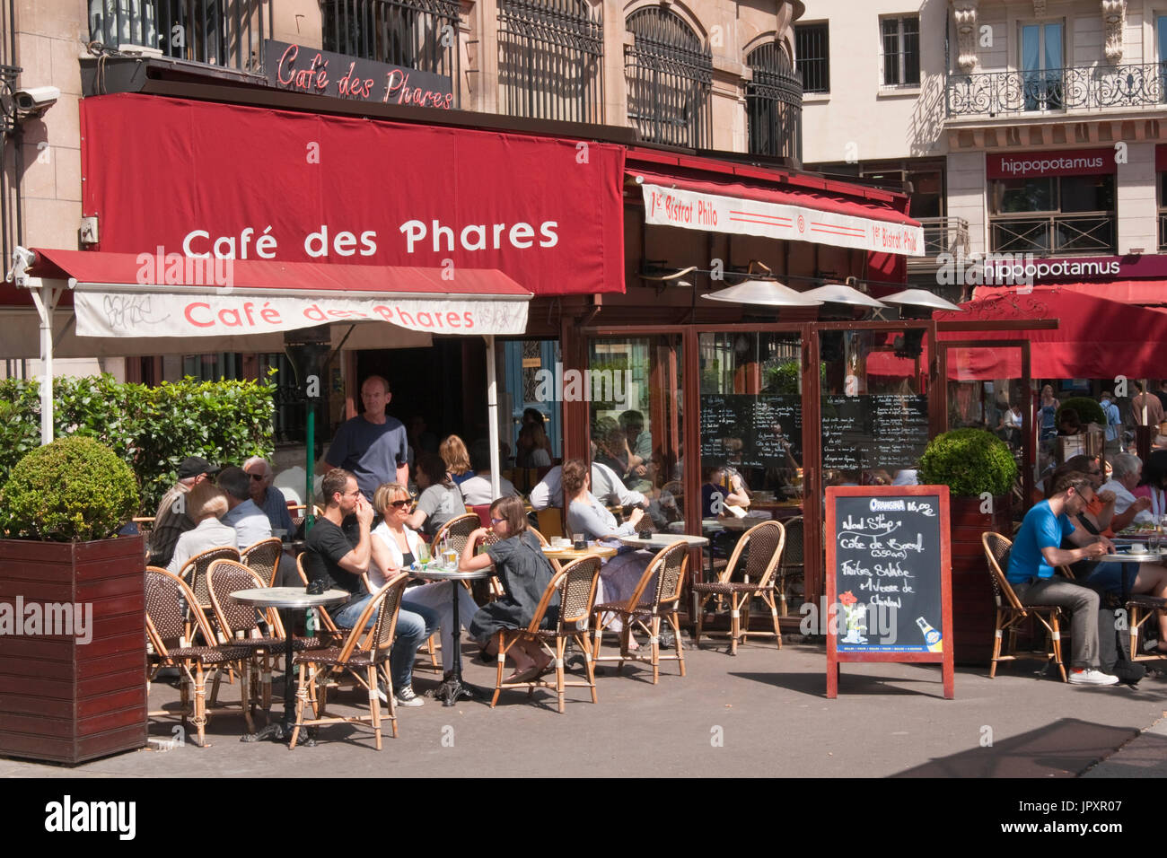 Street cafe filled with people in Paris, France Stock Photo