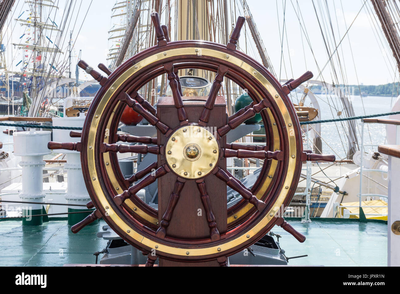 Travel background with a wooden helm closeup. Ship wheel on the old