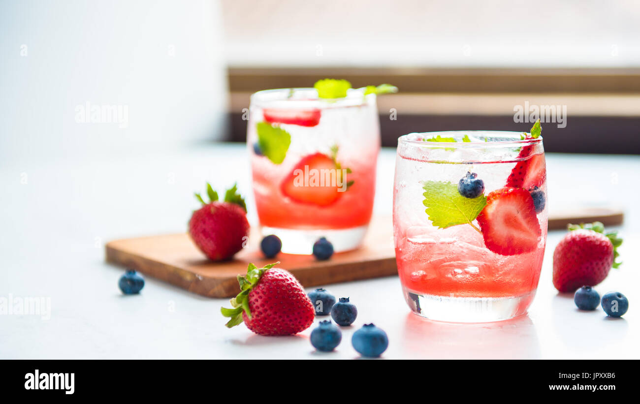 set cocktails strawberry and blueberry mix soda for healty drink but mix whisky for party enjoy Stock Photo