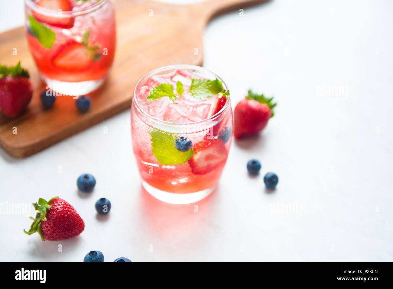 set cocktails strawberry and blueberry mix soda for healty drink but mix whisky for party enjoy Stock Photo
