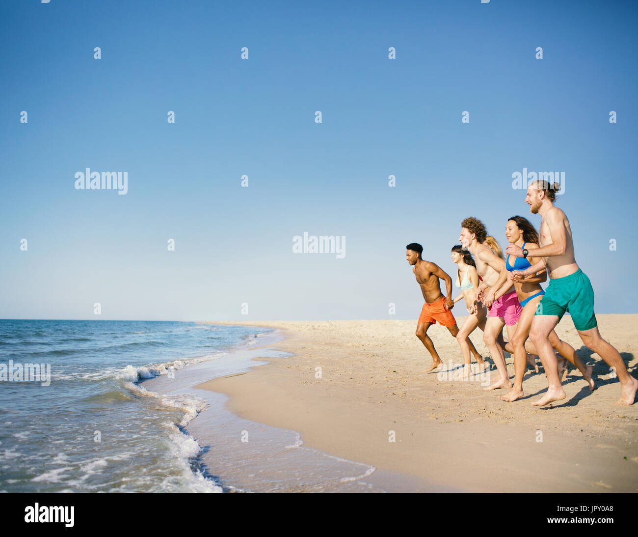 Group of friends run to the sea. Concept of summertime Stock Photo