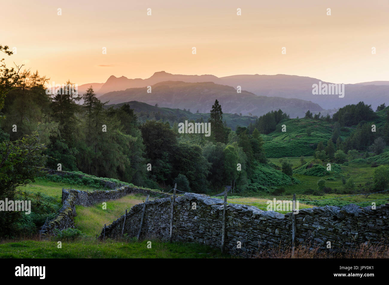 Distant view of the Langdale Pikes and associated Lakeland Fells at dusk  from the hills  above Hawkshead near Tarn Hows in the English Lake District Stock Photo