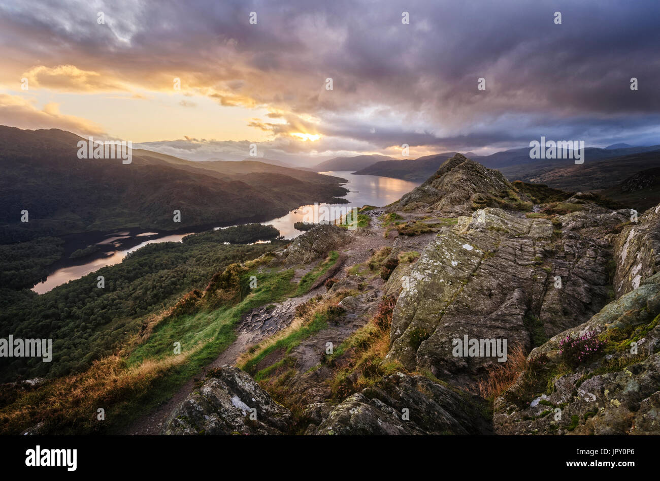 Dramatic Sunset Sky over Loch Katrine in the Trossachs in Scotland from the rocky summit of Ben A'an  a popular small mountain or hill Stock Photo