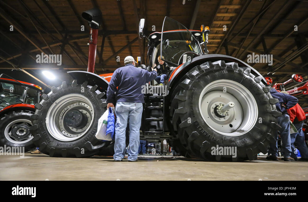 Rock Island, Iowa, USA. 15th Jan, 2017. Scott Strickland of Princeton helps his son Cooper, 4, down from a Case tractor at the Quad-City Conservation Alliance Expo Center in Rock Island on Sunday, January 15, 2017. The 26th annual Quad-Cities Farm Show spans from Jan. 15-17 featuring over 200 agriculture companies and a variety of available products. Credit: Andy Abeyta/Quad-City Times/ZUMA Wire/Alamy Live News Stock Photo