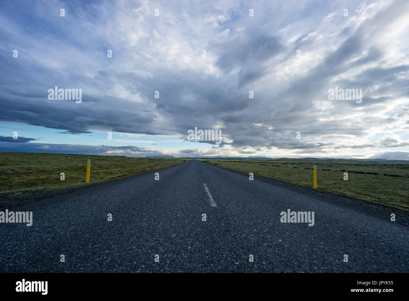 Iceland - Bolt upright street between wide green land and mountains Stock Photo