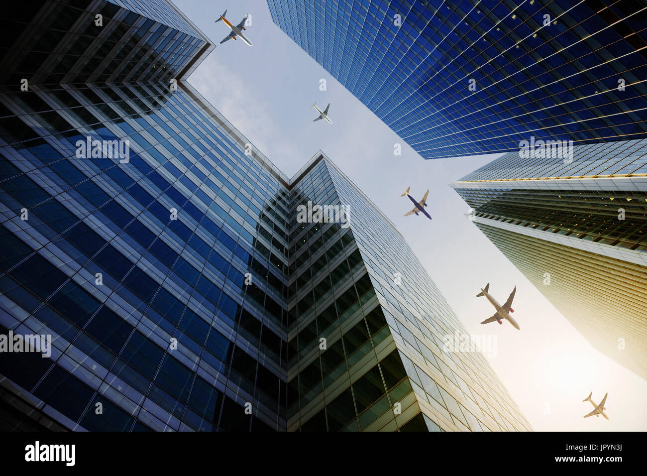 Airplanes flying in a row over highrise buildings, travel concept Stock Photo