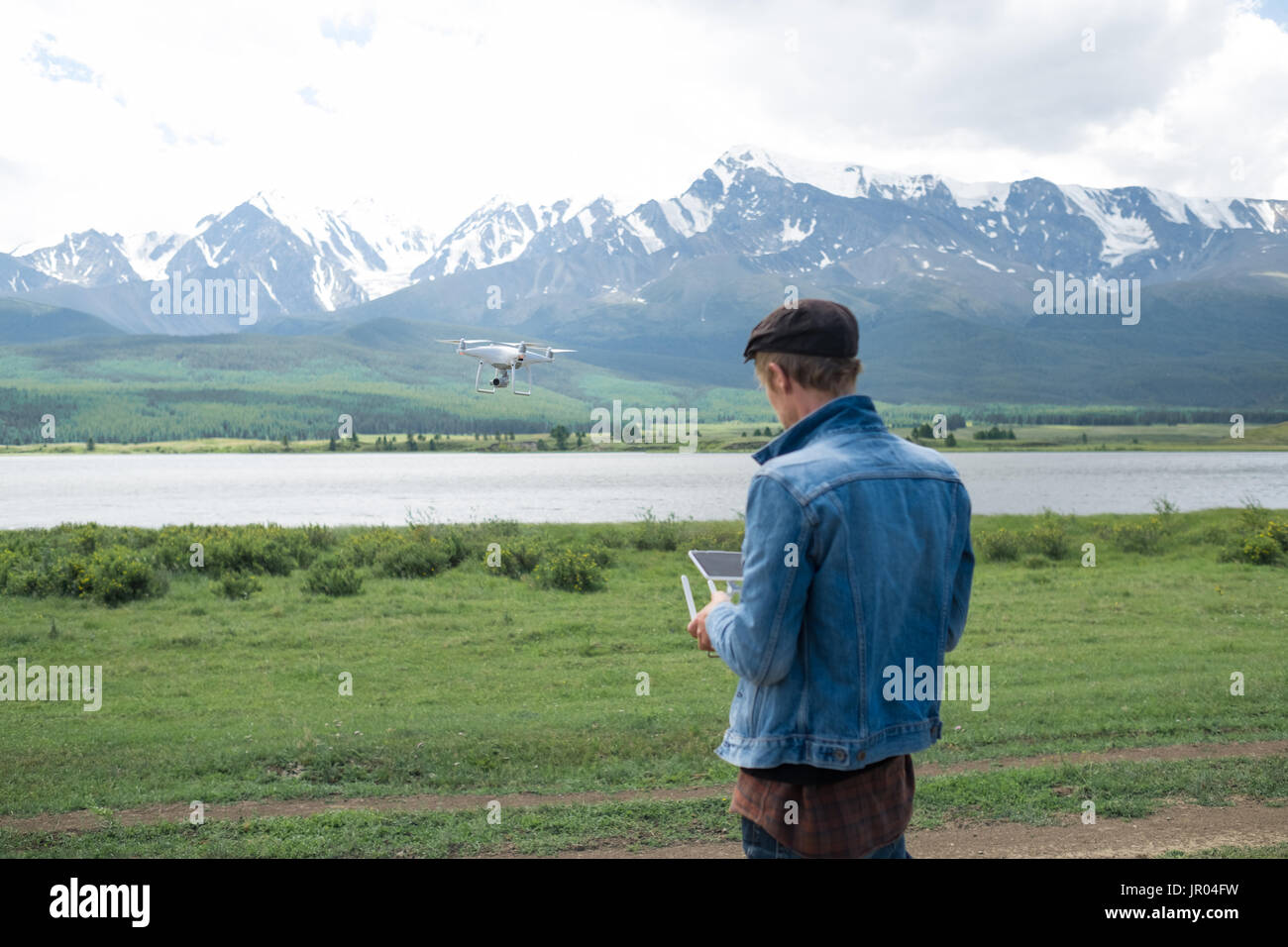 Man controling a drone on mountain background. Stock Photo