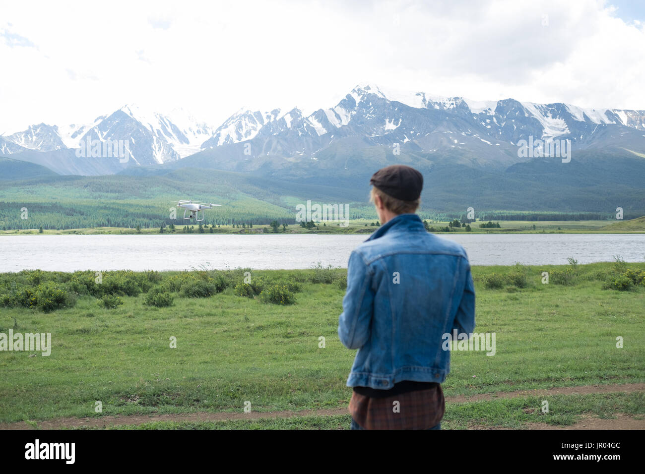 Man controling a drone on mountain background. Stock Photo