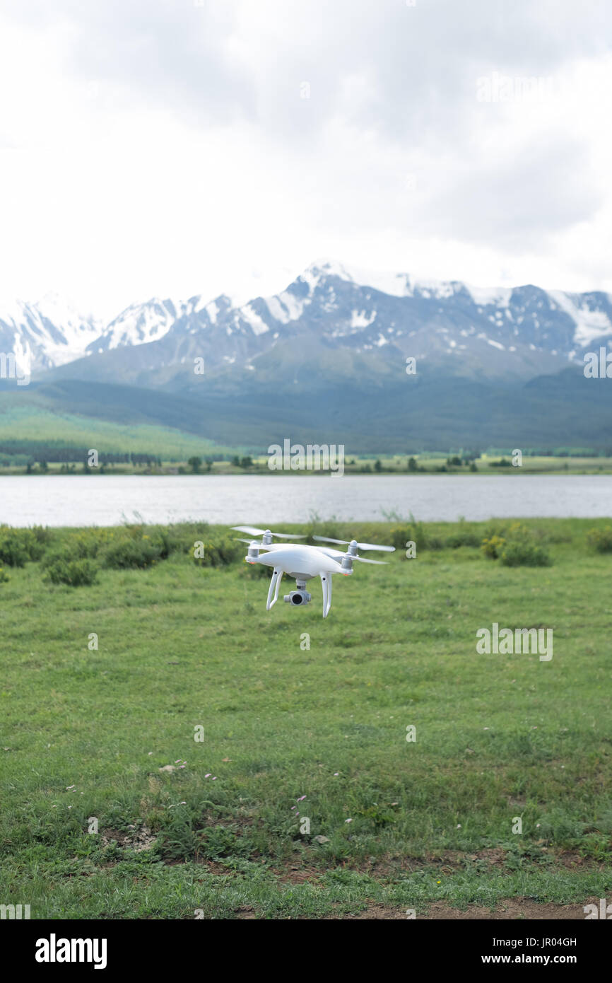 Man controling a drone on mountain background. Stock Photo