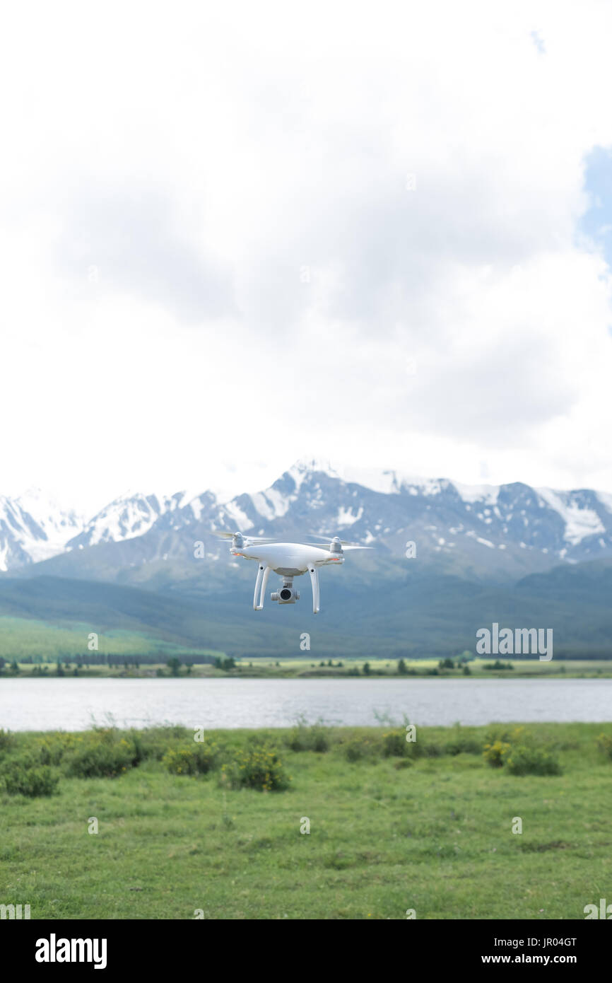 Man controling a drone on mountain background. Stock Photo