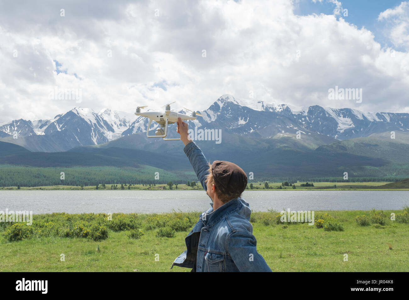 Man controling a drone on mountain background. Stock Photo