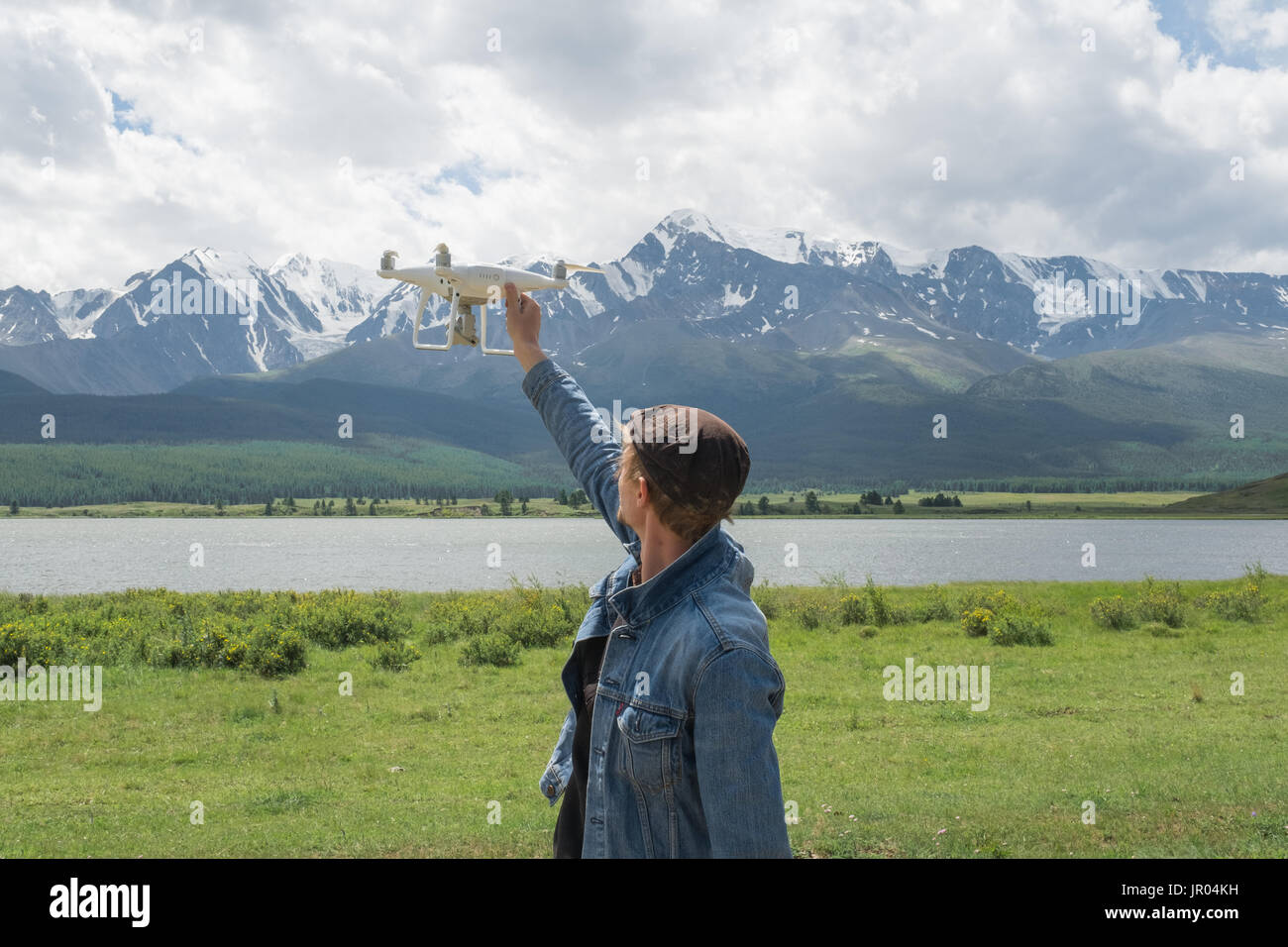Man controling a drone on mountain background. Stock Photo