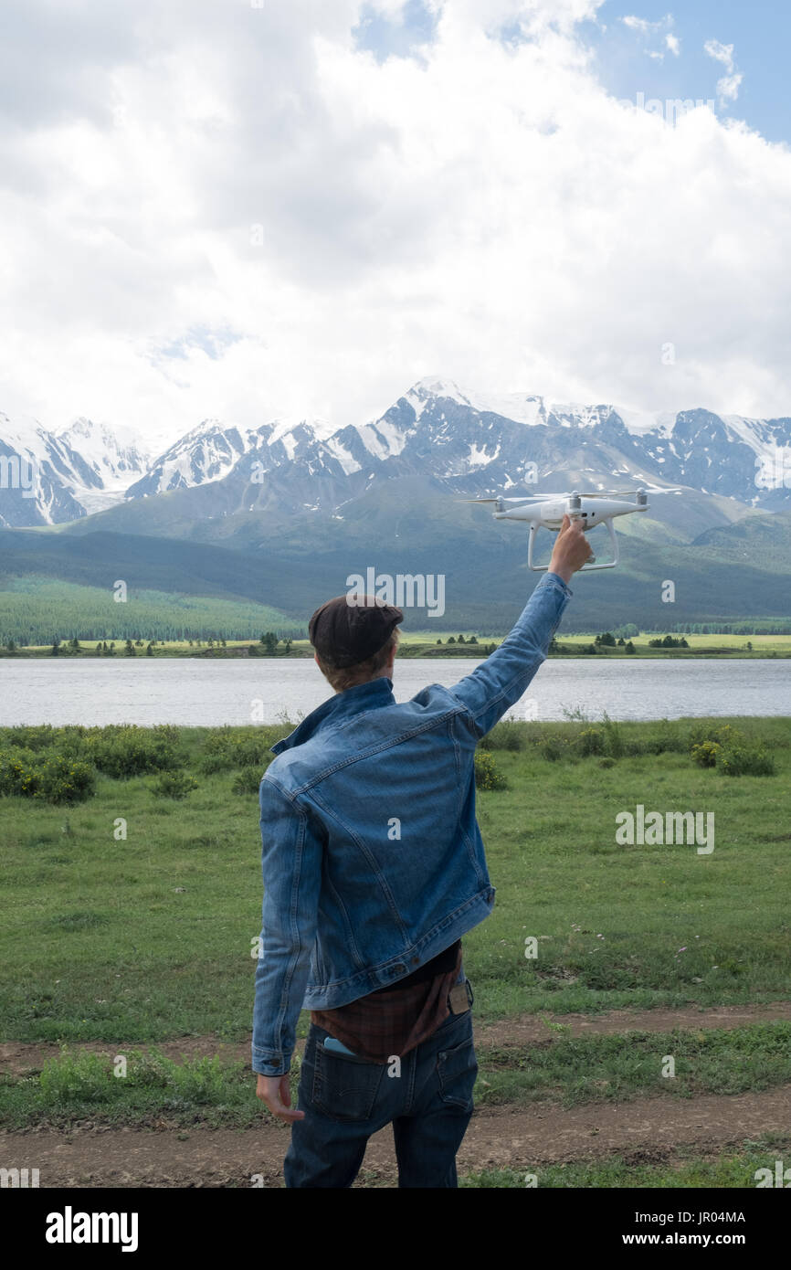 Man controling a drone on mountain background. Stock Photo