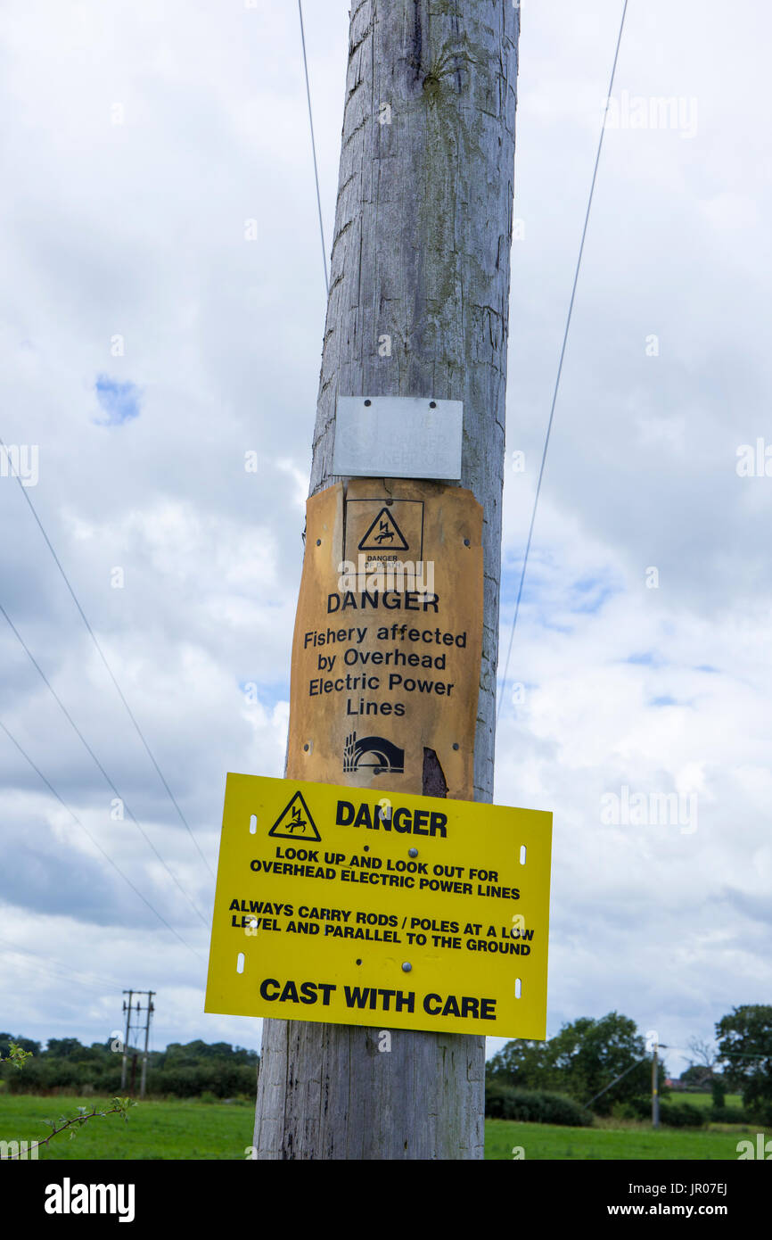Danger sign for fisherman warning them for overhead electric power lines UK Stock Photo