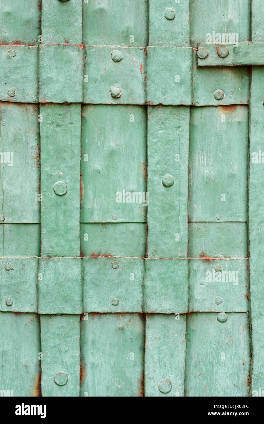 Backgrounds and textures old green painted riveted metal door closeup