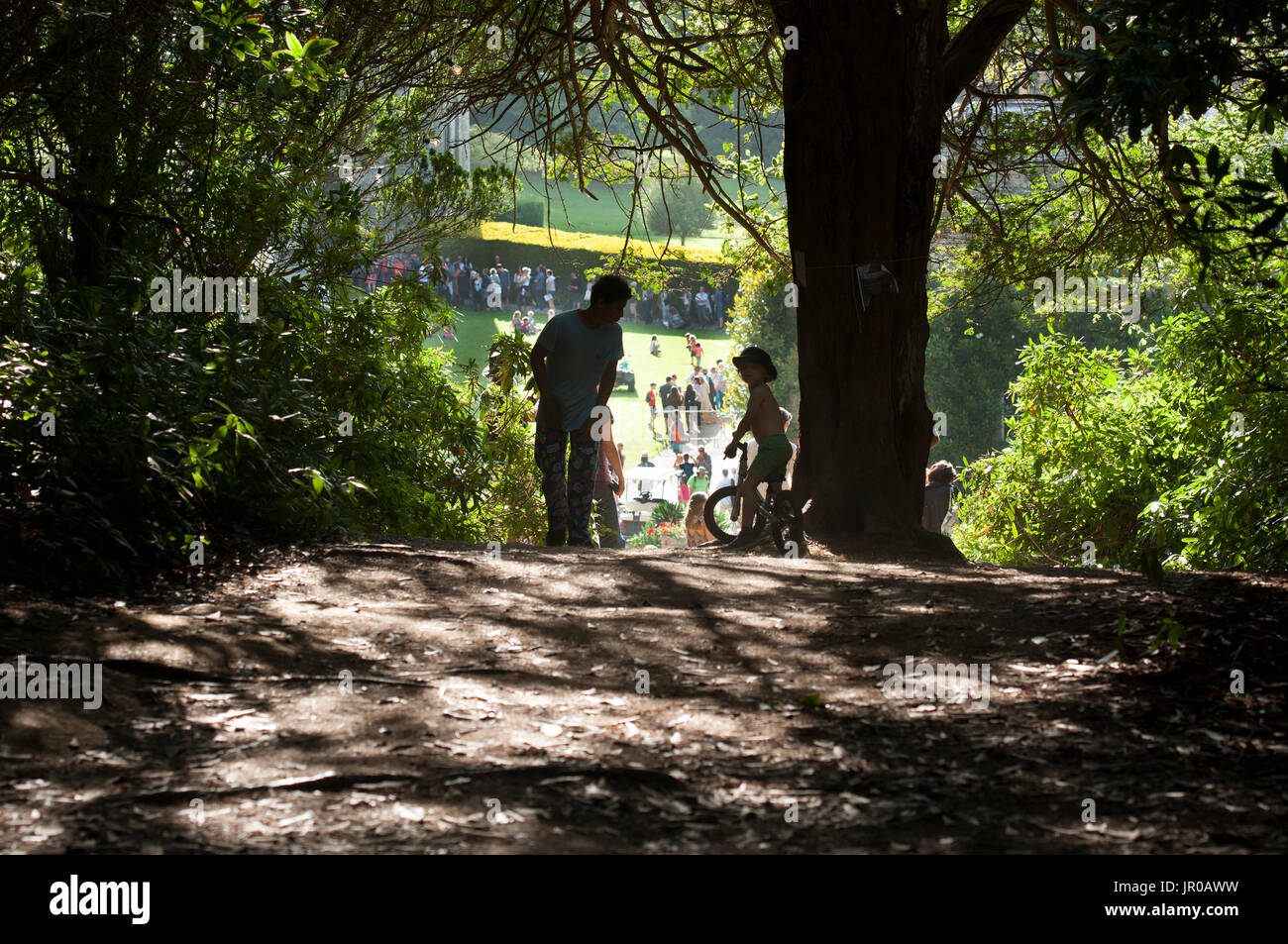 Children playing in the shadows of the trees at the Port Eliot Festival Cornwall UK Stock Photo