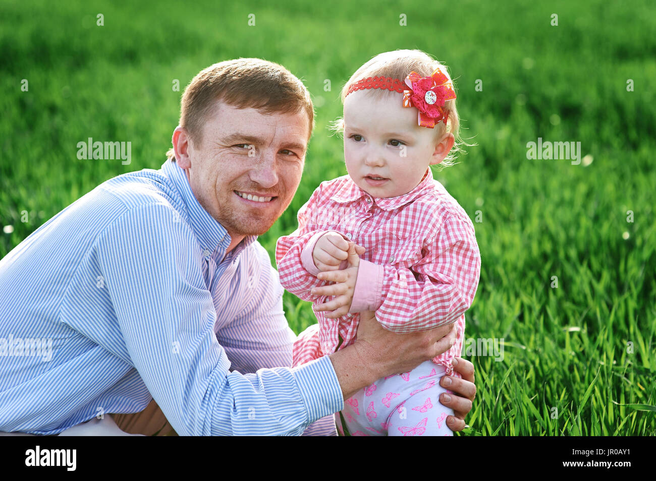 Little girl with dad walking on a summer meadow Stock Photo