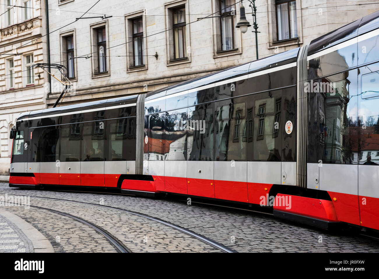 A Modern Electric Train Makes It's Way Over Cobblestone Streets; Prague