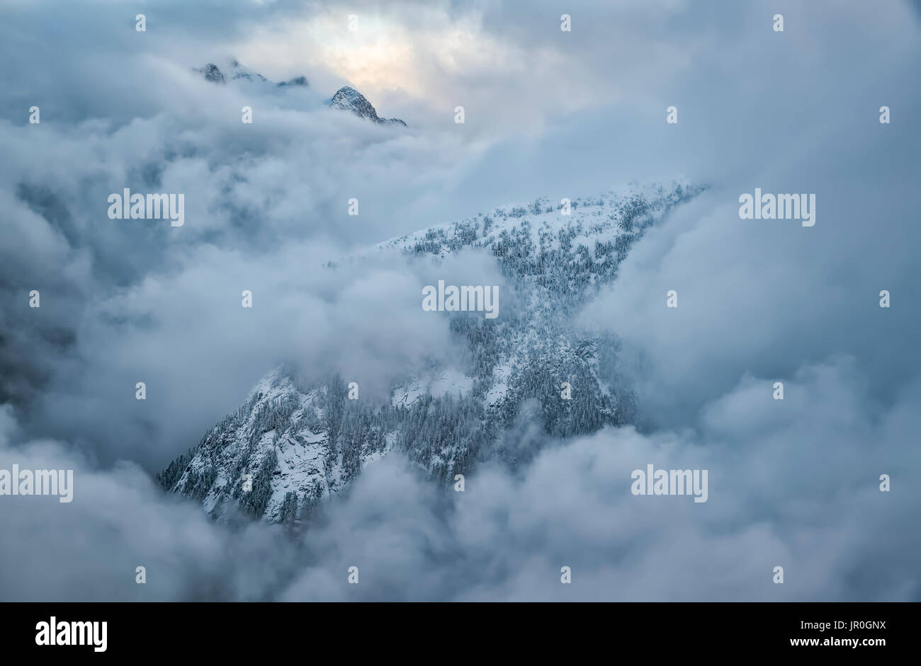 The Mountains Of Golden Ears Provincial Park Are Shrouded In Clouds In The Aerial Photo; British Columbia, Canada Stock Photo