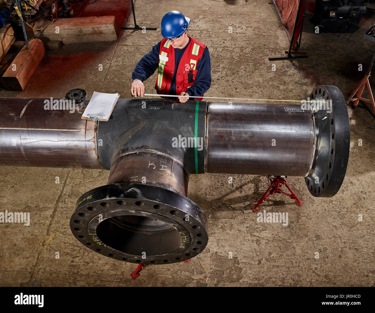 A Tradesman Measures A Pipe For Documentation; Edmonton, Alberta