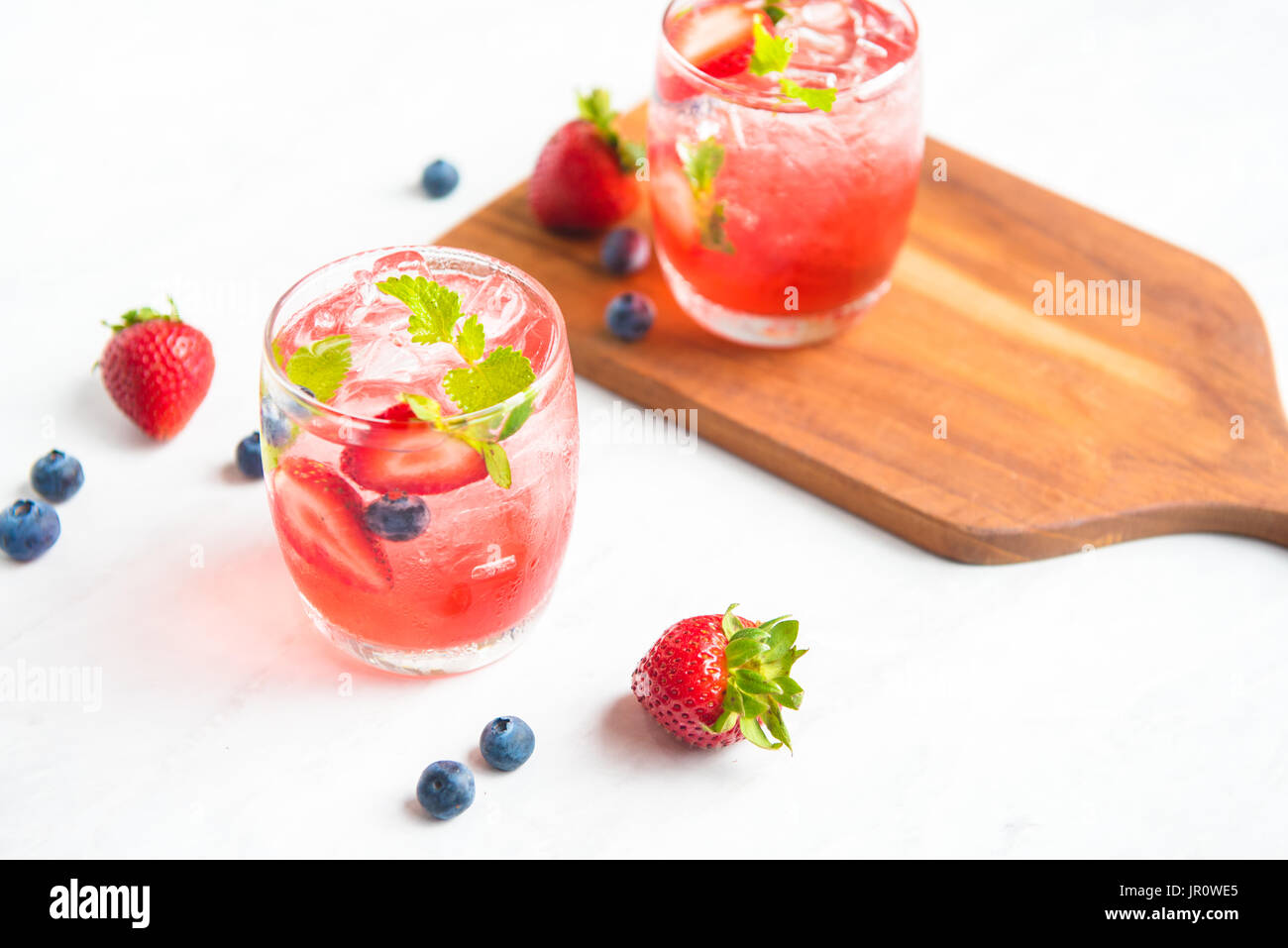 set cocktails strawberry and blueberry mix soda for healty drink but mix whisky for party enjoy Stock Photo