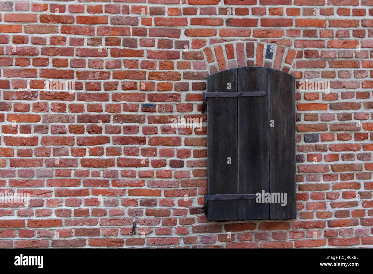 Window in an old red brick wall closed with wooden shutter Stock Photo ...