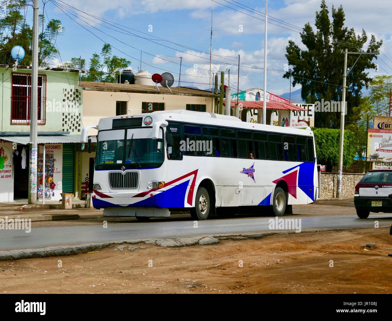 Regional bus parked, Mexican State of Oaxaca, with one passenger looking out a window. Transportation mainly for locals and for high school students. Stock Photo