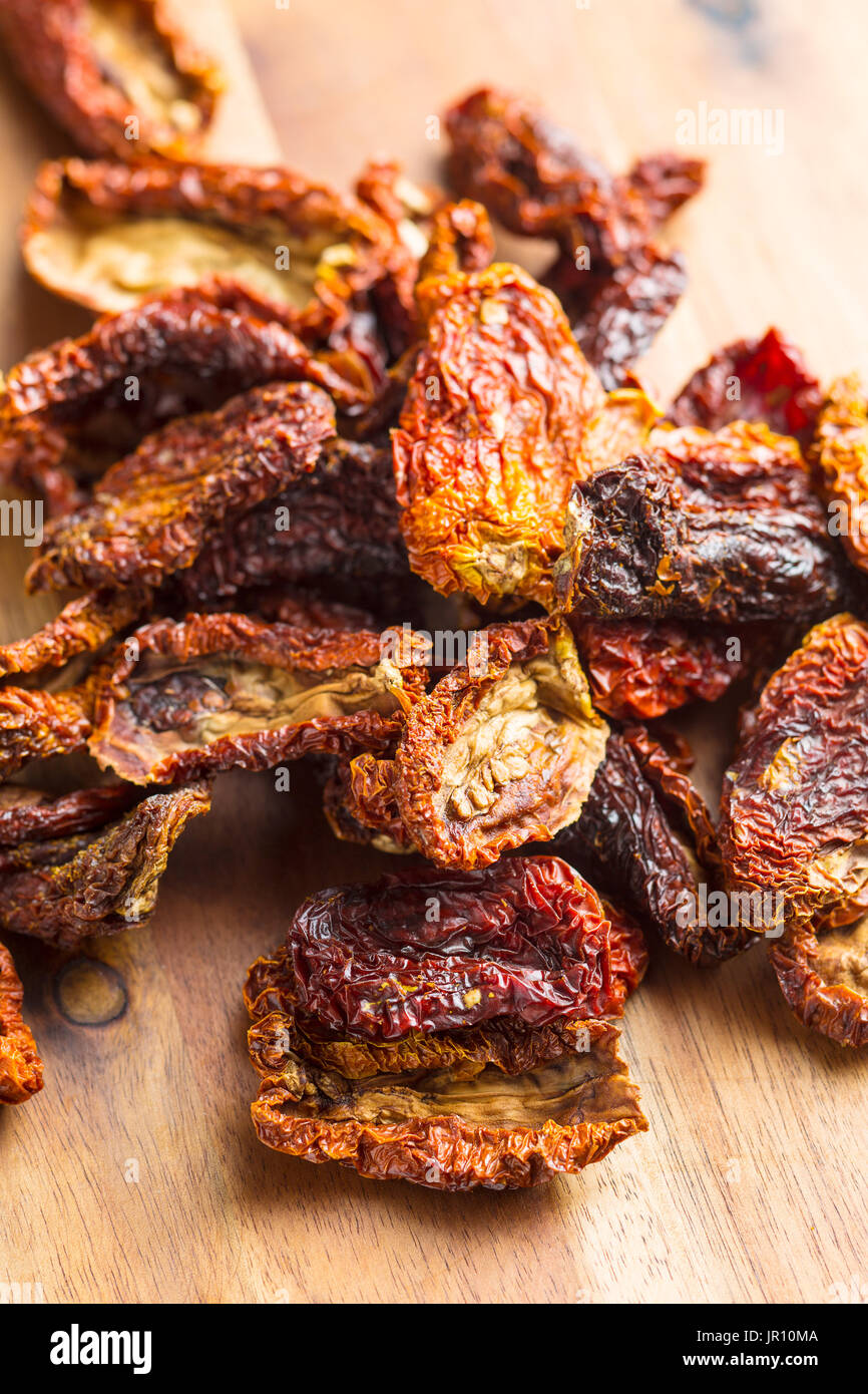 Dried sliced tomatoes on wooden table. Tomatoes as superfood. Stock Photo