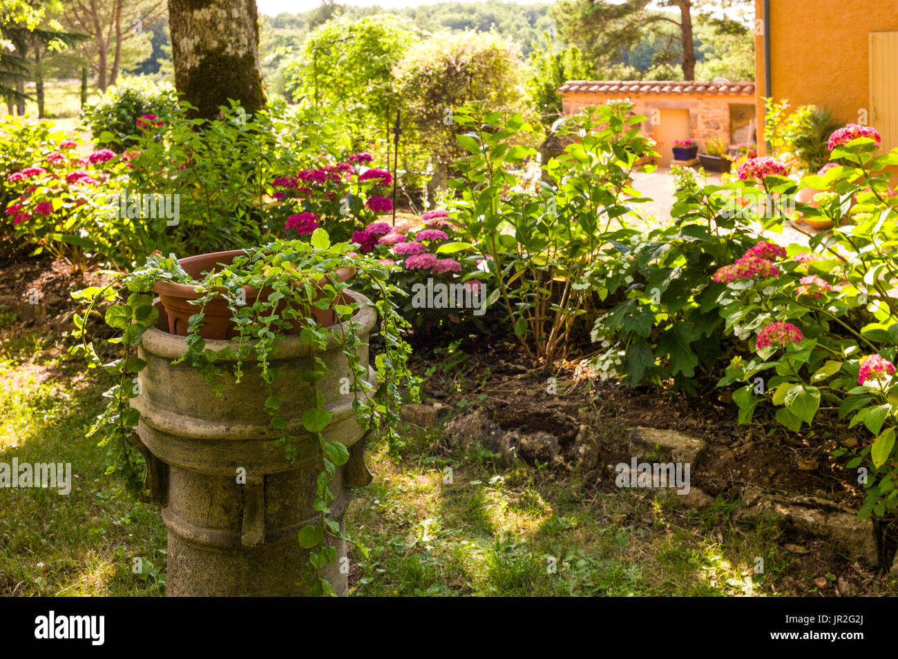 Stone plinth in old French country garden Stock Photo