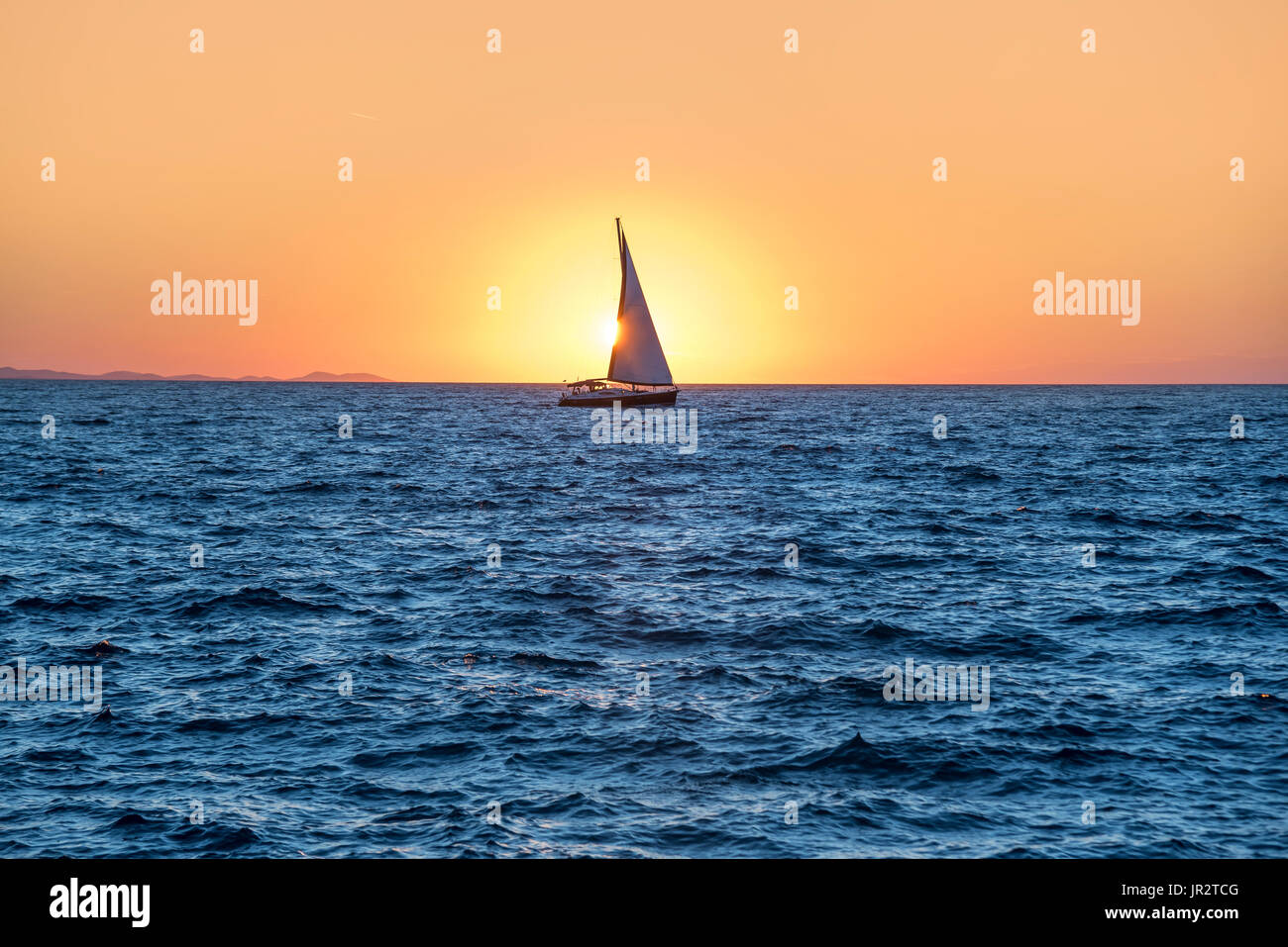 Sailing yacht in the sea at sunset Stock Photo - Alamy