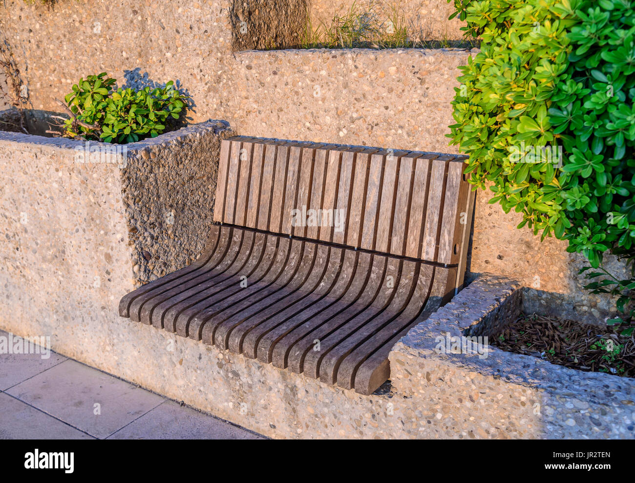 Wooden bench in a stone architectural structure. Stock Photo