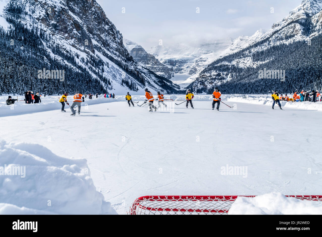 A Pair Of Hockey Teams Compete In Pond Hockey On Lake Louise At The Fairmont Chateau Lake Louise Pond Hockey Tournament In The Winter Stock Photo